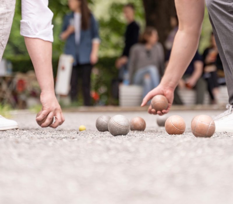 Bocce players collect boules after petanque outdoor game in city park